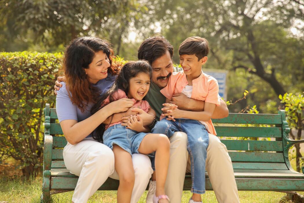 Happy family laughing together on a park bench